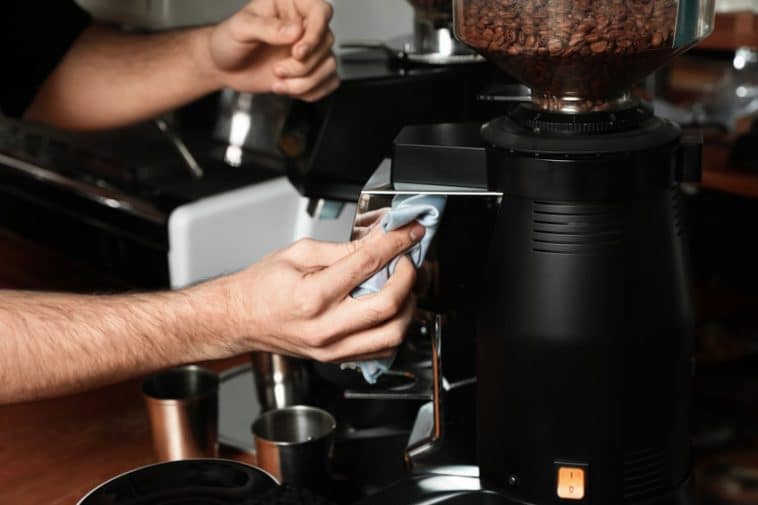 Homme nettoyant machine expresso